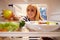 Woman Looking Inside Fridge Full Of Food And Choosing Apple