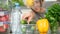 Woman looking inside a fridge full of food and choosing vegetables.