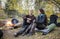 Woman Looking At Man Grinding Coffee During Camping In Forest