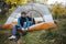 Woman Looking At Man Wearing Hiking Boot In Tent