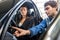 Woman Looking At Mechanic Checking Light Switch Of Car