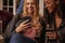 Woman Looking At Message On Mobile Phone At Party