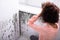 Woman Looking At Mold On Wall