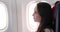 Woman looking out through airplane window