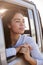 Woman looking out of front passenger car window, vertical