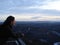 Woman looking out of the lookout to the landscape at dusk