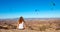 woman looking at paraglider in the desert