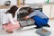 Woman Looking At Repairman Repairing Dishwasher