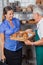 Woman Looking At Senior Salesman Holding Tray Of