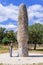 Woman looking at the Standing Stone / Menhir of Meada, the largest of the Iberian Peninsula
