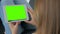 Woman looking at tablet computer with green screen