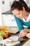 Woman looking tablet reading recipe kitchen vegetables