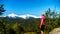 Woman looking at the Tantalus Mountain Range with snow covered peaks of Alpha Mountain, Serratus and Tantalus Mountain