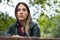 Woman looking thoughtful. Sitting on the bench outdoors, in the park.