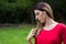 Woman looking thoughtful. Walking arround, outdoors, in the park.