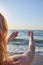 Woman looking to the sea ocean from the back naked with windy hair. the girl pulls her hands to the sea