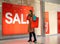 Woman looking at window shop - Sale in clothes shop