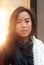 Woman looks at camera as bright display lights are visible over her shoulder