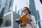 A woman looks in her notebook standing, in the middle of the business centre