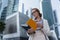 A woman looks in her notebook standing, in the middle of the business centre