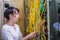 A woman looks at the multitude of tangled wires in the server room. The network administrator fixes problems in the work of the