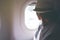 Woman looks out the window of an flying airplane wings view. Young passengers are traveling by plane, watching the sky from above