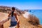 Woman looks on panoramic landscape Petra tou Romiou The rock of the Greek, Aphrodite`s legendary birthplace in Paphos, Cyprus