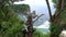 Woman looks at picturesque landscape and rise hands. Atuh beach, Nusa Penida island