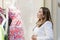 A woman looks into a shop window with fashionable mannequins in a beautiful boutique. Close-up