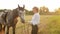 woman loves her gray horse. Field at sunset, active lifestyle, outdoor. Freedom in nature. Friendship between people and