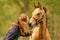 Woman lovingly kisses the foal on his nose