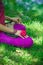 Woman lower body in lotus posture on grass by lake practice yoga