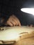 woman luthier maker carving the violin plate with thumb plane in the workshop with dim light