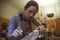 A woman luthier is tuning a classic guitar in her musical instrument workshop