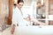 Woman in luxurious hotel bathroom letting water in the bathtub