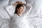 Woman lying alone in comfortable bed after night sleep