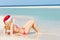 Woman Lying On Beach Wearing Santa Hat