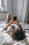 Woman lying on the bed and using smartphone, woman using smartphone at home in the bedroom selective focus