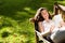 Woman lying on bench and using digital tablet in garden on a sunny day