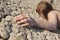 Woman lying on cracked land with focus on hand