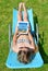 Woman lying on lounger in garden.