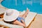 Woman lying on a lounger by the pool at the hotel