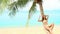 woman lying on palm tree at the beach