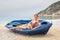 Woman lying in rowing boat on greek beach