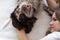 Woman lying with russian spaniel dog brown different colours eyes. face to face