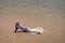 Woman lying on sea beach. Fashion and beauty.