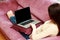 Woman lying on the sofa with laptop at home and looking on the blank screen