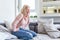 Woman lying on sofa looking sick in the living room. Beautiful young woman lying on bed and holding hands on her stomach. Woman