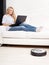 Woman lying on the sofa, and the robot vacuum cleaner cleans