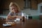 Woman lying at the table, depressed, lonely, sick, despondent, unhappy, suffering, among pills